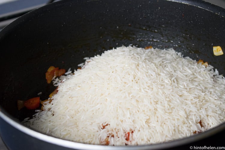 rice added to pan for jollof rice recipe
