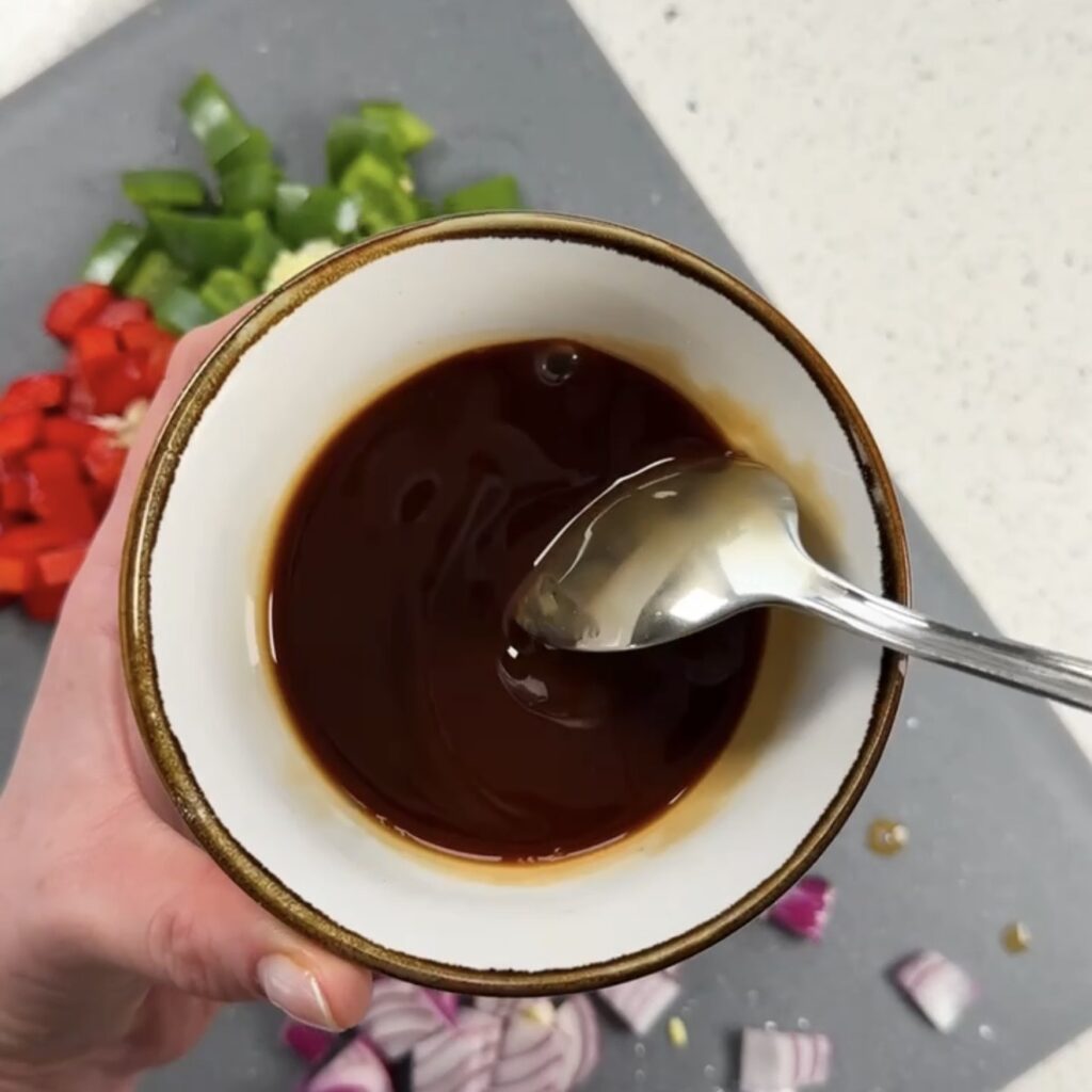 Honey garlic soy sauce being mixed together in a small white bowl