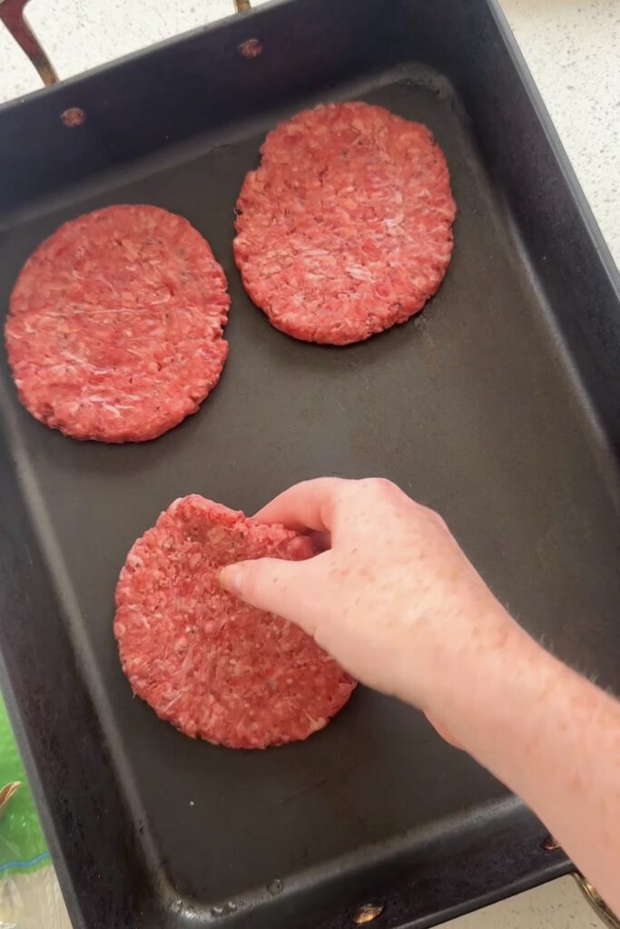 laying smash burgers on a baking tray